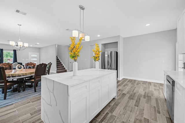 3409 2nd Ave N, Texas City, TX 77590 - kitchen with white cabinets, a chandelier, stainless steel appliances, wood tiled floor, and visible vents