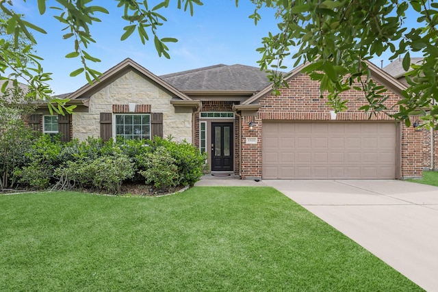 ranch-style house featuring a garage, a front yard, stone siding, roof with shingles, and driveway