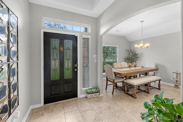 foyer with an inviting chandelier, arched walkways, baseboards, and lofted ceiling
