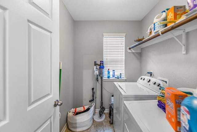 clothes washing area with independent washer and dryer, laundry area, plenty of natural light, and baseboards