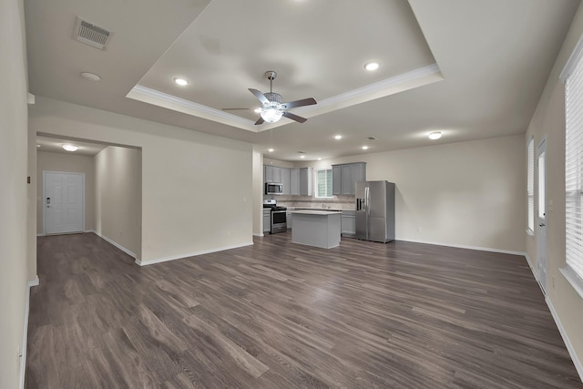 4202 Amber Ruse Dr, Conroe, TX 77304 - unfurnished living room featuring baseboards, a tray ceiling, visible vents, and a ceiling fan