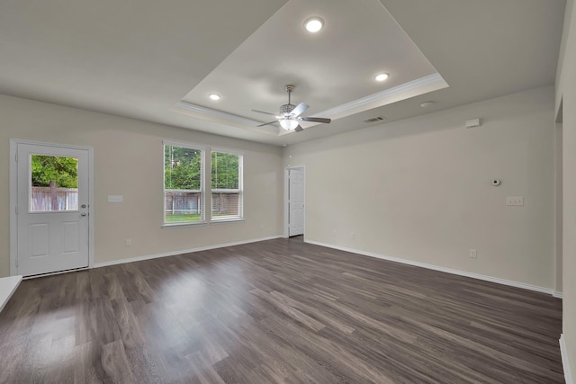 4202 Amber Ruse Dr, Conroe, TX 77304 - unfurnished living room with a tray ceiling, a wealth of natural light, visible vents, and dark wood finished floors