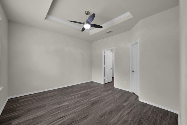 4202 Amber Ruse Dr, Conroe, TX 77304 - unfurnished bedroom with a tray ceiling, baseboards, dark wood-type flooring, and visible vents