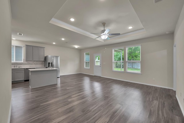 4202 Amber Ruse Dr, Conroe, TX 77304 - unfurnished living room featuring baseboards, a raised ceiling, ceiling fan, and visible vents