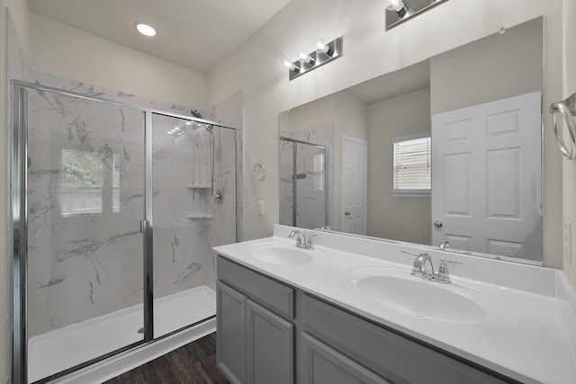 4202 Amber Ruse Dr, Conroe, TX 77304 - bathroom with double vanity, a marble finish shower, wood finished floors, and a sink