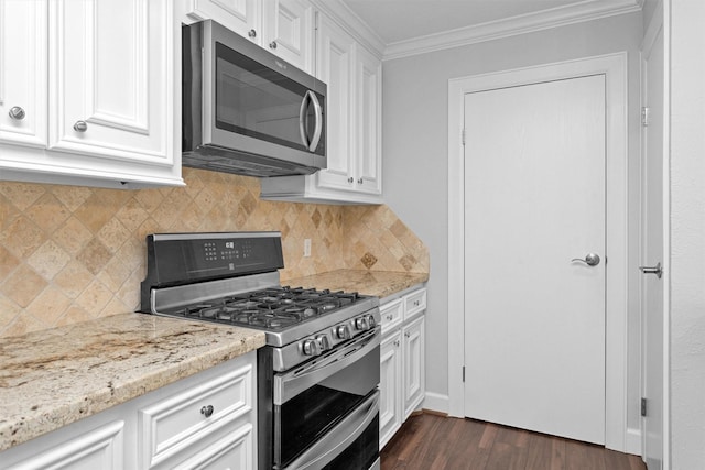 91 Bitterwood Cir, The Woodlands, TX 77381 - kitchen featuring crown molding, appliances with stainless steel finishes, light stone countertops, dark wood finished floors, and white cabinets