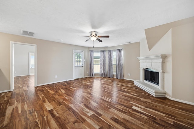2411 Lacyberry St, Houston, TX 77080 - unfurnished living room with ceiling fan, wood finished floors, a fireplace with raised hearth, baseboards, and a textured ceiling