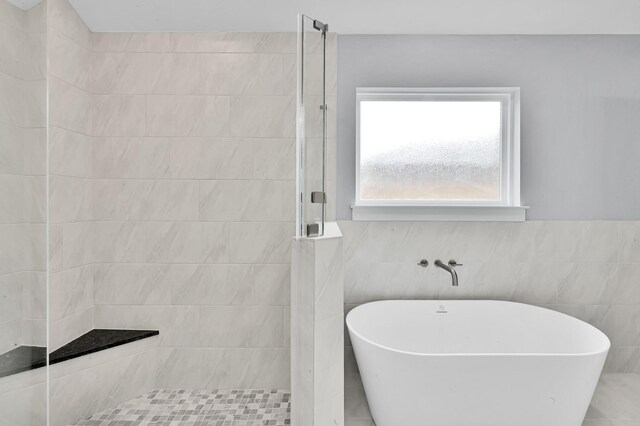 12390 Green Ridge Dr, Willis, TX 77318 - full bathroom with a walk in shower, a freestanding tub, and tile walls