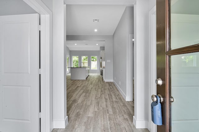 12390 Green Ridge Dr, Willis, TX 77318 - hall featuring a sink, light wood-style floors, recessed lighting, baseboards, and visible vents