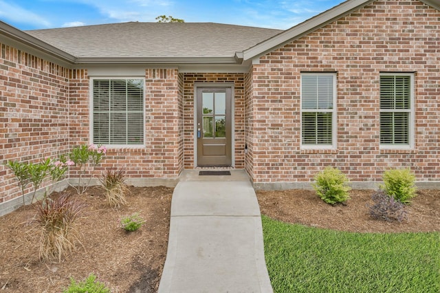 12390 Green Ridge Dr, Willis, TX 77318 - view of exterior entry featuring brick siding and a shingled roof