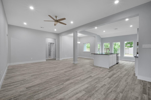 12390 Green Ridge Dr, Willis, TX 77318 - unfurnished living room featuring ceiling fan, a sink, baseboards, recessed lighting, and light wood-style flooring