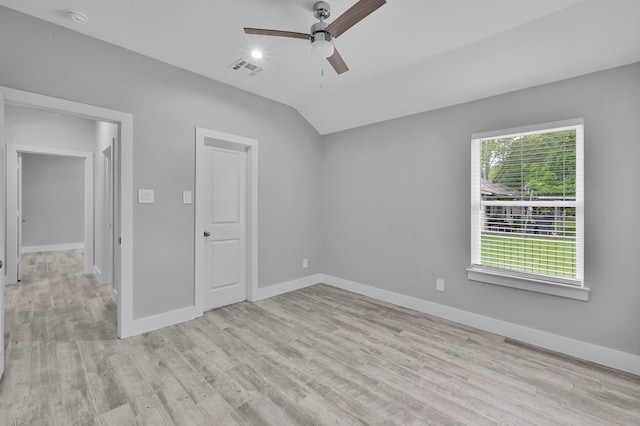 12390 Green Ridge Dr, Willis, TX 77318 - unfurnished bedroom with baseboards, visible vents, light wood-style flooring, and lofted ceiling