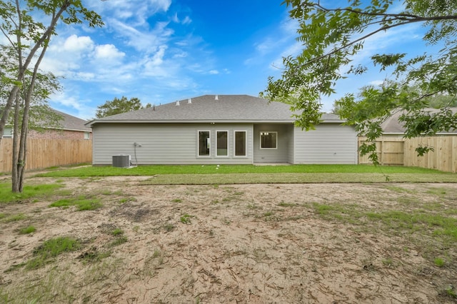 12390 Green Ridge Dr, Willis, TX 77318 - back of property with fence, a shingled roof, a yard, and central AC