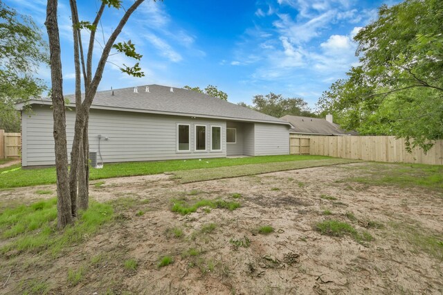 12390 Green Ridge Dr, Willis, TX 77318 - rear view of property featuring fence and a shingled roof