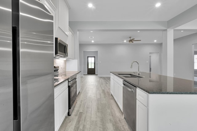 12390 Green Ridge Dr, Willis, TX 77318 - kitchen featuring light wood-type flooring, a sink, stainless steel appliances, recessed lighting, and an island with sink