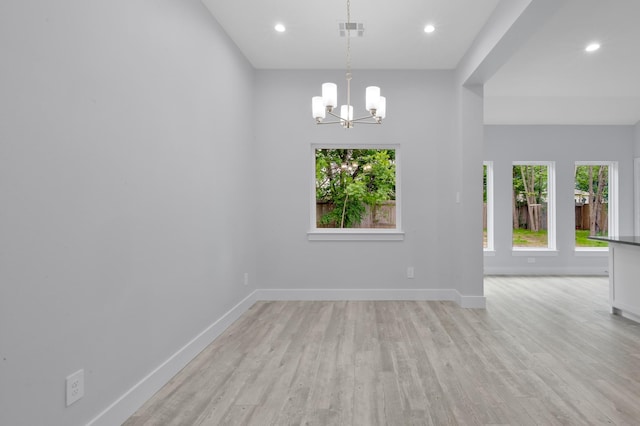 12390 Green Ridge Dr, Willis, TX 77318 - unfurnished room featuring light wood-style floors, baseboards, a chandelier, and visible vents