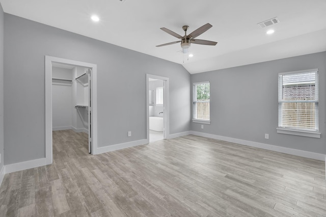 12390 Green Ridge Dr, Willis, TX 77318 - unfurnished bedroom with a walk in closet, ceiling fan, visible vents, baseboards, and light wood-style floors