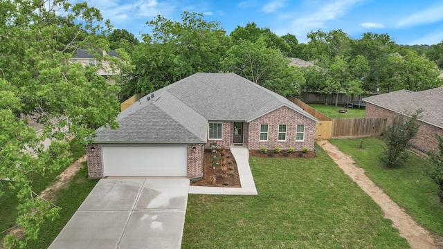 12390 Green Ridge Dr, Willis, TX 77318 - view of front of home with fence, a shingled roof, brick siding, a garage, and concrete driveway