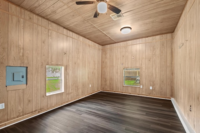empty room featuring ceiling fan, wood walls, wooden ceiling, wood finished floors, and visible vents