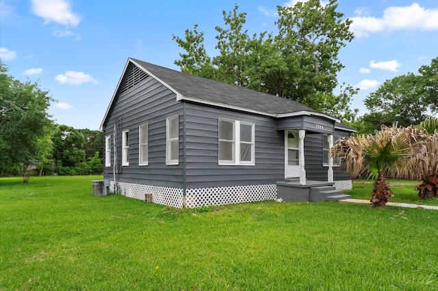 view of front of property with central AC unit and a front yard