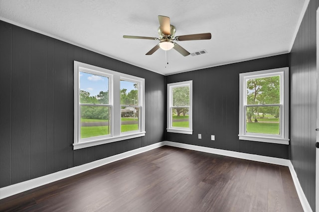 unfurnished room with baseboards, a ceiling fan, wood finished floors, and visible vents
