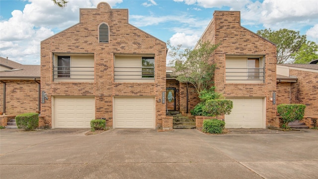 view of front facade with brick siding, driveway, and a garage