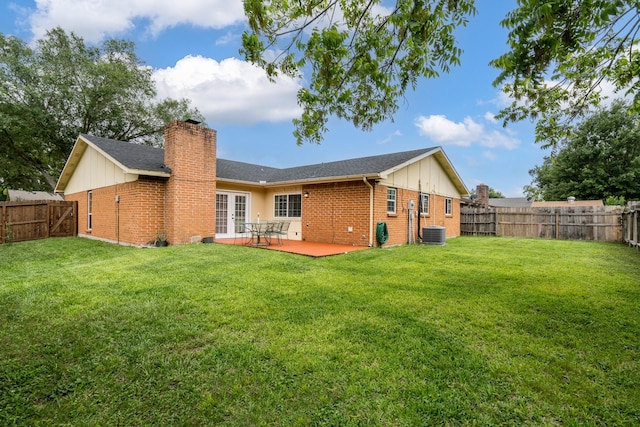 back of house with a fenced backyard, french doors, a chimney, brick siding, and central air condition unit