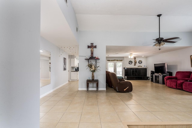 living room with french doors, a ceiling fan, a towering ceiling, and light tile patterned flooring