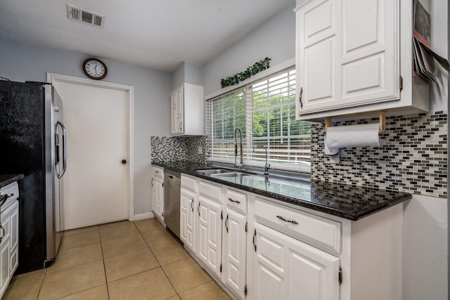 kitchen featuring backsplash, visible vents, appliances with stainless steel finishes, a sink, and white cabinetry