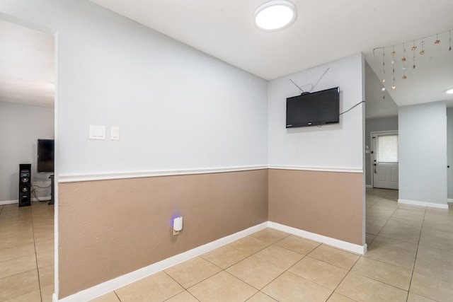 spare room with light tile patterned floors and baseboards
