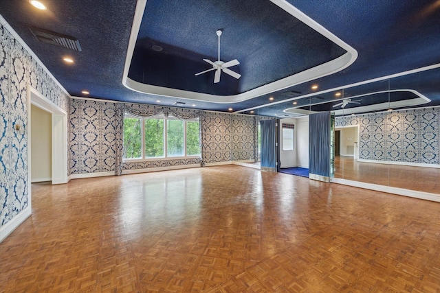 unfurnished living room featuring baseboards, ceiling fan, wallpapered walls, and visible vents