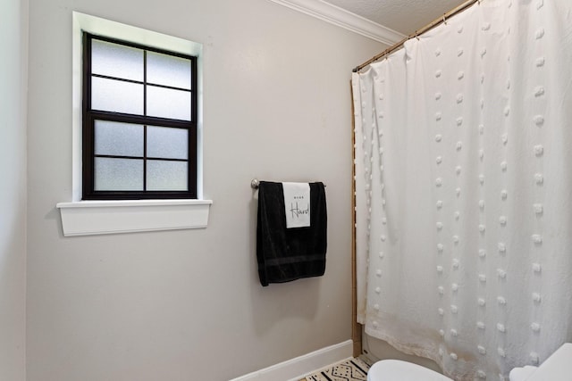 bathroom with baseboards, ornamental molding, toilet, and curtained shower