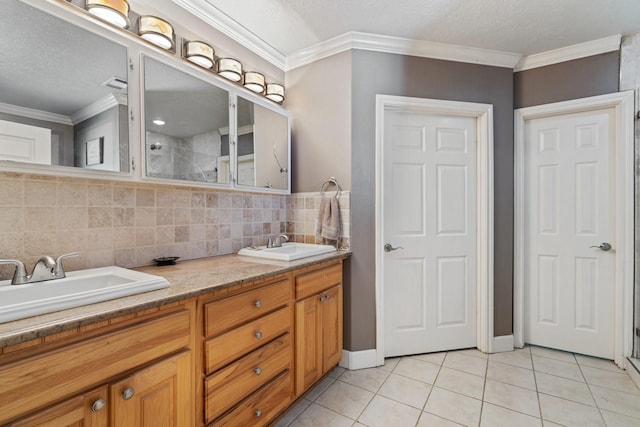bathroom featuring a sink, tile patterned flooring, tasteful backsplash, and crown molding