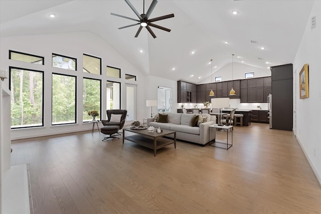 15631 Audubon Park Dr, Magnolia, TX 77354 - living room with high vaulted ceiling, light wood-style flooring, a ceiling fan, and recessed lighting
