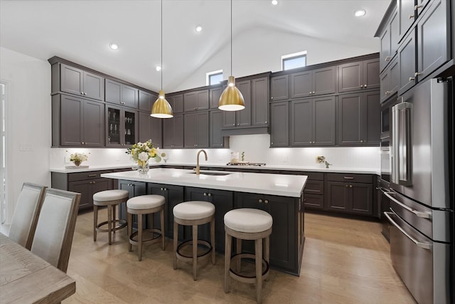 15631 Audubon Park Dr, Magnolia, TX 77354 - kitchen featuring appliances with stainless steel finishes, a sink, light wood-style floors, a kitchen bar, and recessed lighting