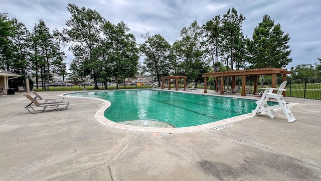 community pool featuring a patio, a pergola, and fence