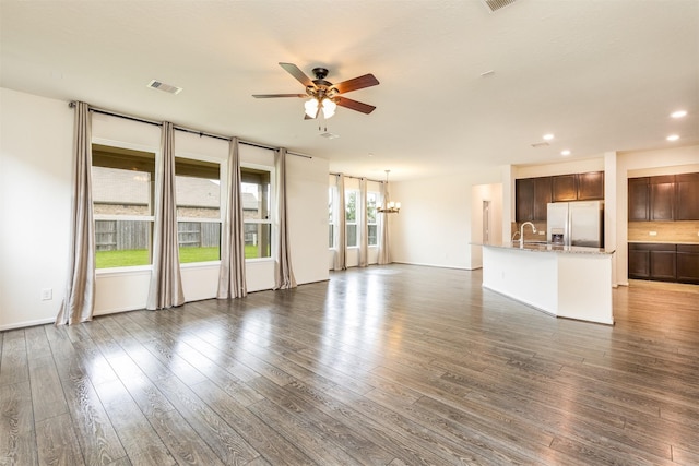 unfurnished living room with a ceiling fan, wood finished floors, recessed lighting, a chandelier, and a sink