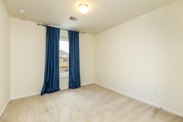 carpeted empty room featuring baseboards and a smoke detector