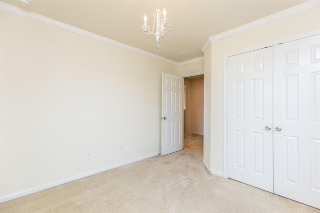 unfurnished bedroom with a chandelier, crown molding, light colored carpet, baseboards, and a closet