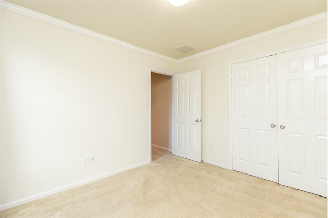 unfurnished bedroom featuring ornamental molding, light colored carpet, baseboards, and a closet
