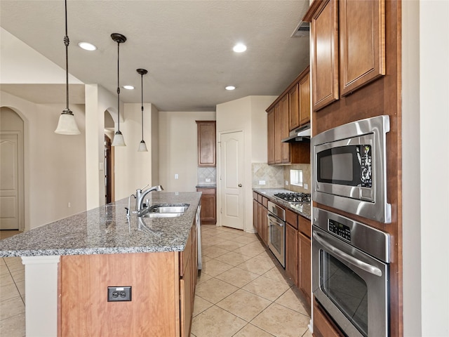2513 Crestmoon Ct, Houston, TX 77089 - kitchen with brown cabinets, tasteful backsplash, a sink, appliances with stainless steel finishes, and light tile patterned floors