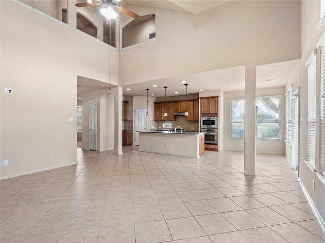 2513 Crestmoon Ct, Houston, TX 77089 - unfurnished living room featuring plenty of natural light, baseboards, ceiling fan, and light tile patterned flooring