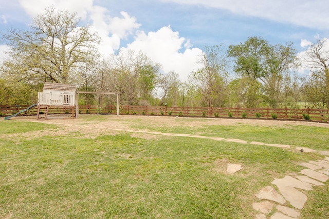 view of yard with a playground, a detached carport, and a fenced backyard