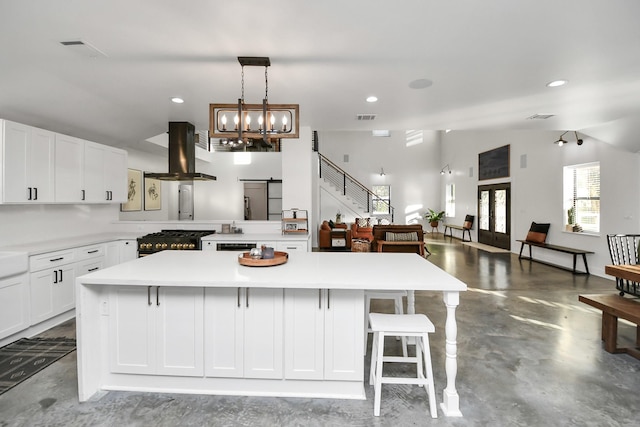23058 Mills Rd, Porter, TX 77365 - kitchen featuring light countertops, gas range oven, concrete floors, and island exhaust hood