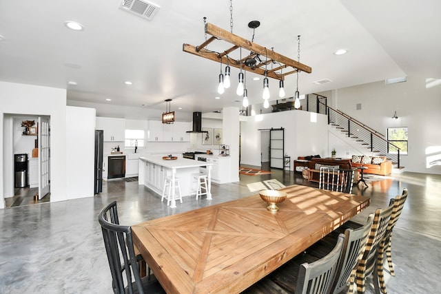 23058 Mills Rd, Porter, TX 77365 - dining area featuring finished concrete floors, a barn door, visible vents, and stairway