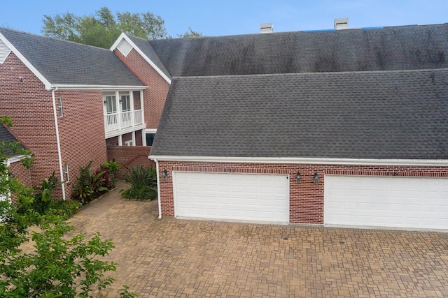 2722 Masters Dr, League City, TX 77573 - exterior space with brick siding, a shingled roof, decorative driveway, and a chimney