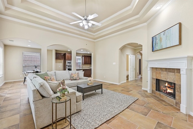 2524 Garnetfield Ln, Friendswood, TX 77546 - living room with a raised ceiling, ornamental molding, ceiling fan, arched walkways, and a tile fireplace