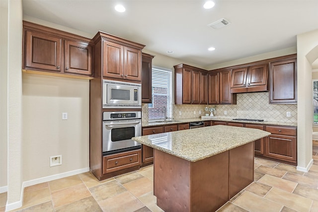 2524 Garnetfield Ln, Friendswood, TX 77546 - kitchen with appliances with stainless steel finishes, a sink, tasteful backsplash, light stone counters, and recessed lighting