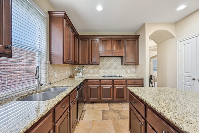 2524 Garnetfield Ln, Friendswood, TX 77546 - kitchen featuring a sink, dishwashing machine, backsplash, arched walkways, and stainless steel gas cooktop