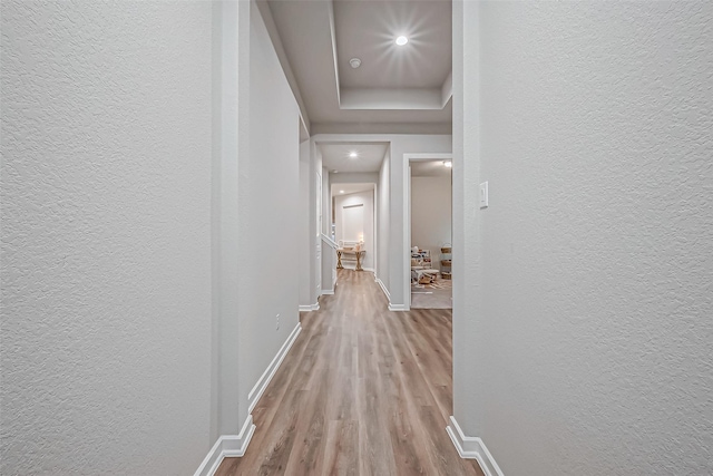 hall with baseboards, recessed lighting, a textured wall, and wood finished floors